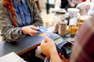 A girl paying for a transaction using her debit/credit card.