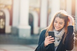 Woman smiling at her phone.