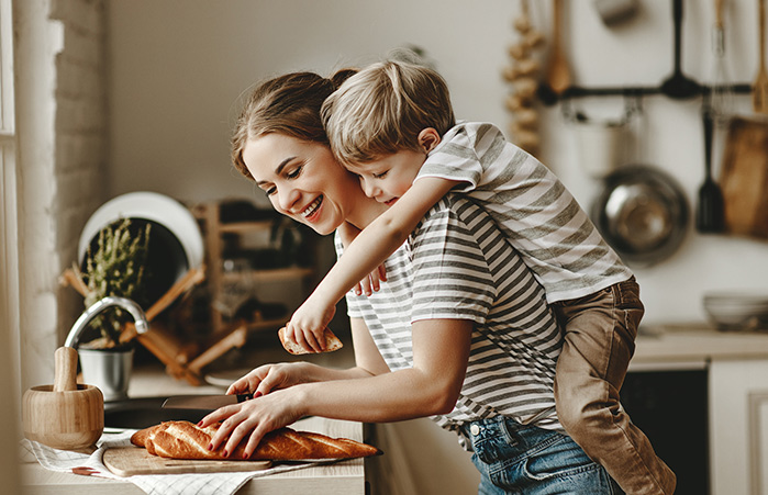 Son on mother back in the kitchen.