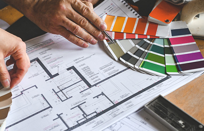 Person looking at paint swatched and blueprints.