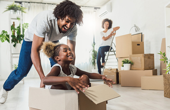Family playing with boxes in their new home.