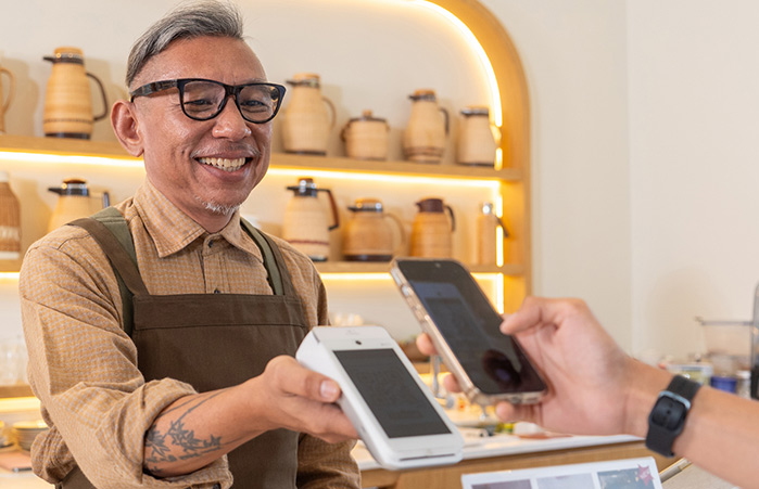 Small business owner presenting a terminal for payment.