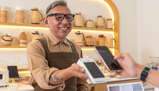 Small business owner taking payment from a phone.