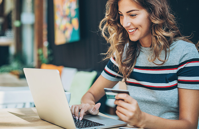 Person holding their credit card on their laptop.