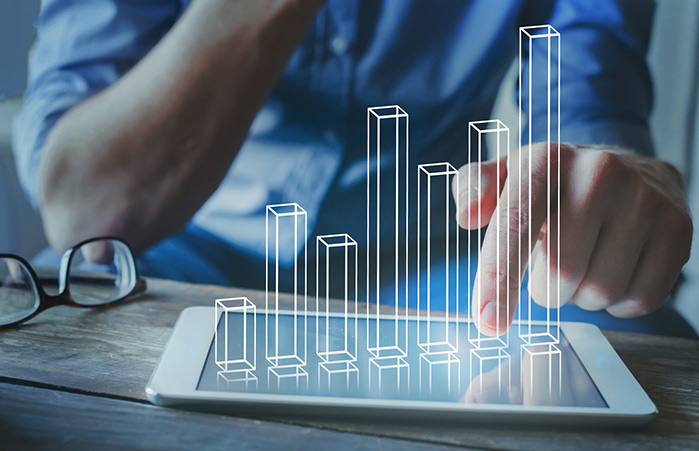Person using a laptop looking at financial graphs.