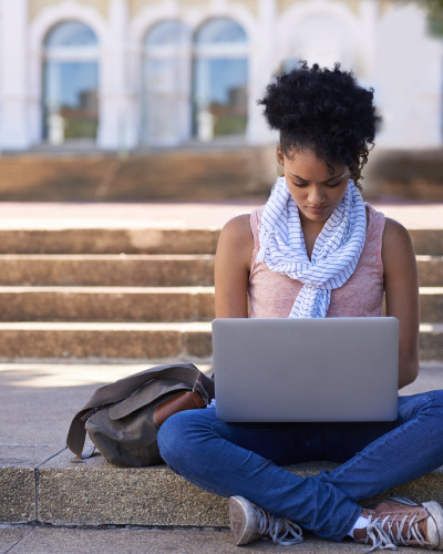 Woman sitting on the ground with her laptop