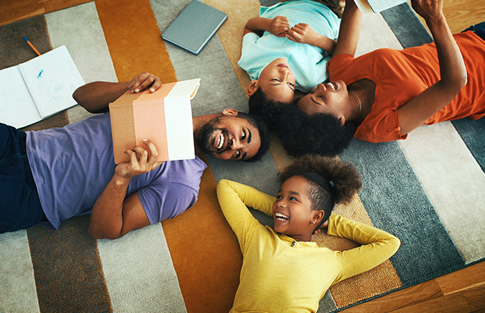 Young family laying on floor smiling.